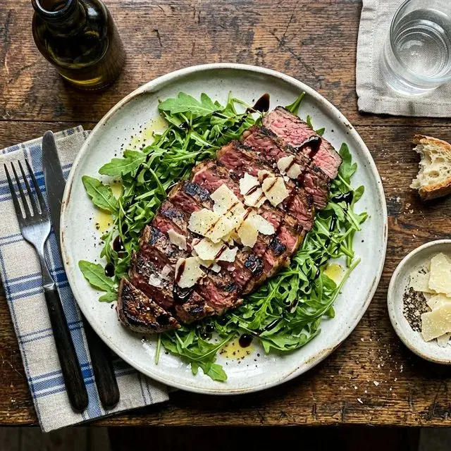 KI-generiertes Symbolbild: Italienische Rinder-Tagliata auf Balsamico-Rucola