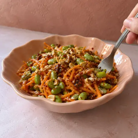 KI-generiertes Symbolbild: Mittagessen und Vegan Rezept für Veganer Karottensalat mit Edamame, Chili-Crisp und Erdnüssen